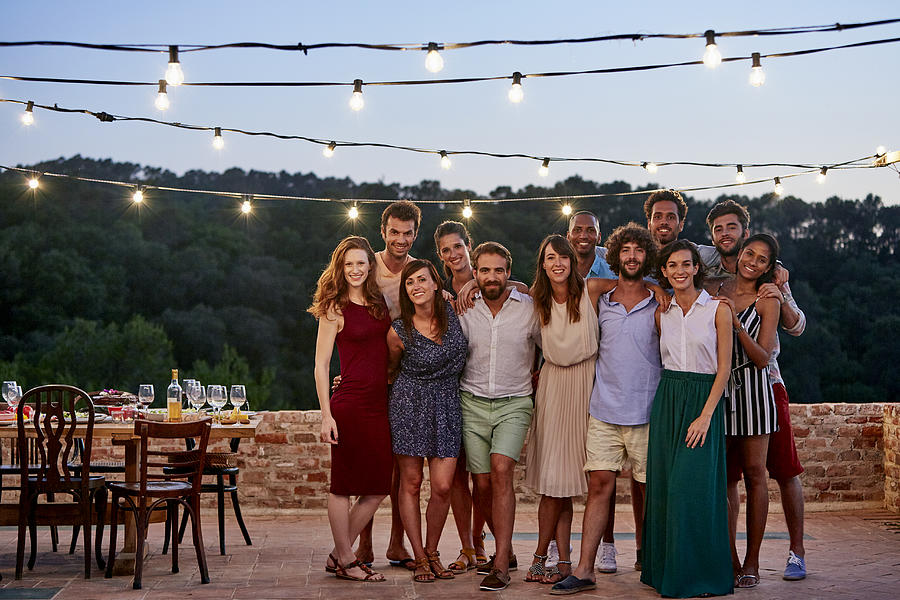 Happy friends standing at patio during gathering Photograph by Morsa Images