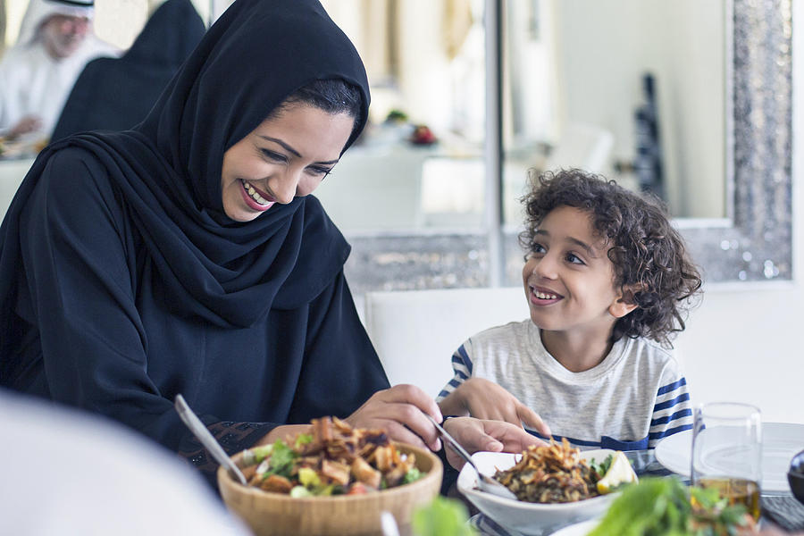 Happy middle Eastern mother and son having lunch Photograph by Xavierarnau