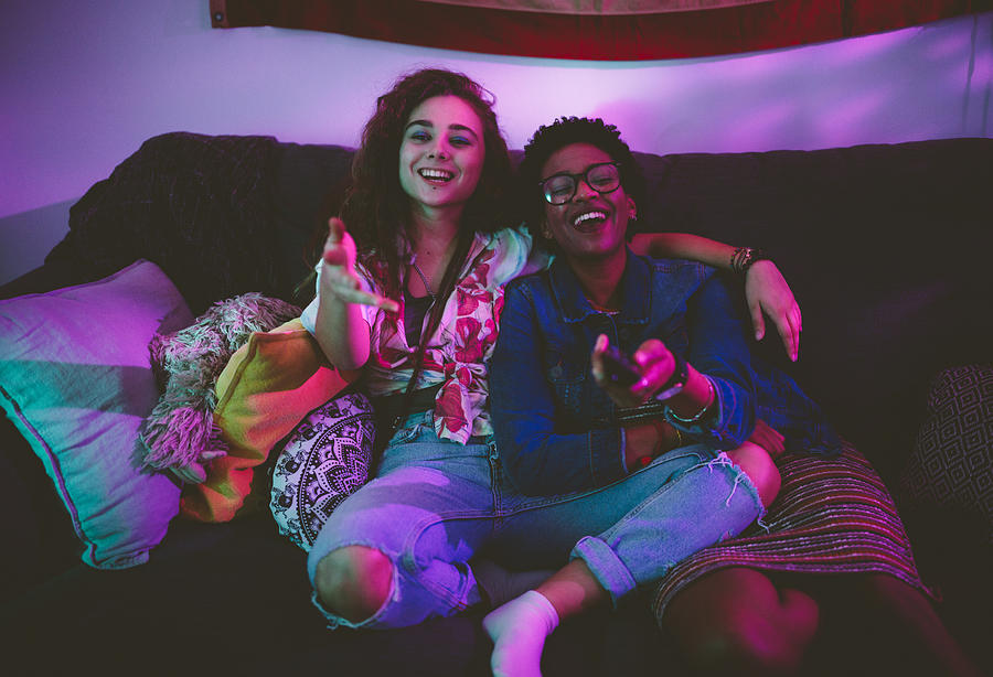 Happy multi-ethnic friends having fun wathing TV together Photograph by Wundervisuals