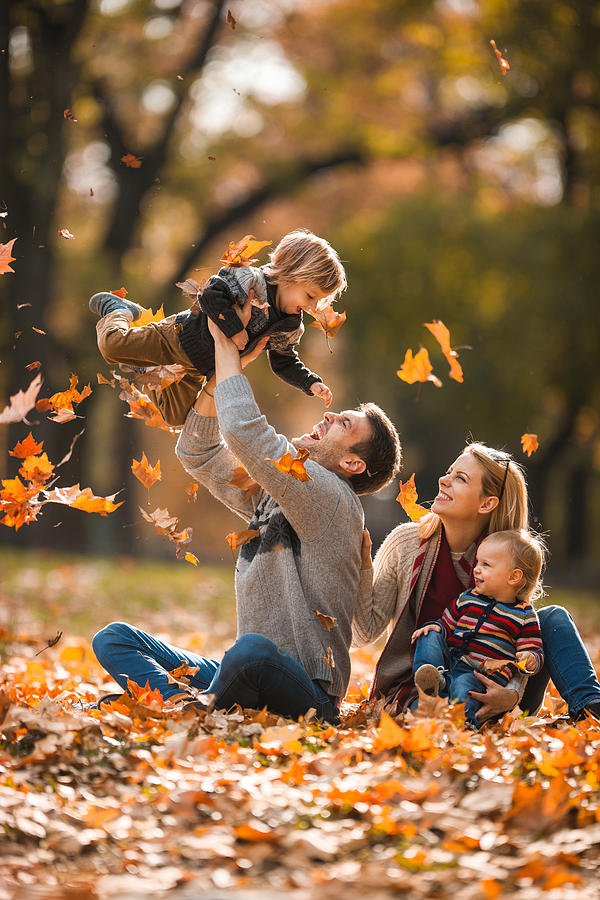 Happy parents having fun with their small children in autumn day. Photograph by Skynesher