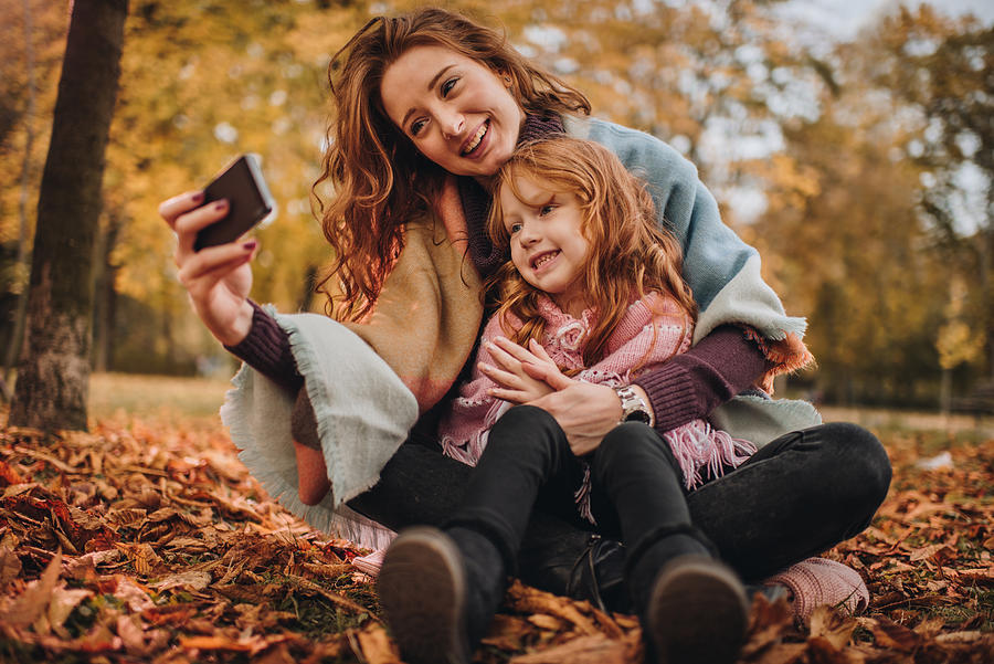 Happy redhead mother and daughter taking a selfie in autumn. Photograph by Skynesher
