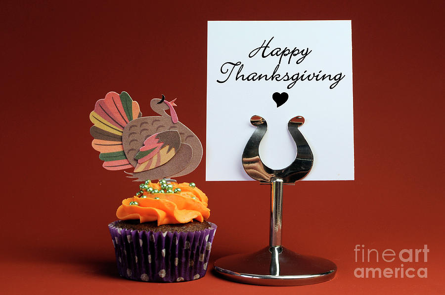 Happy Thanksgiving message on table stand with orange cupcake Photograph by Milleflore Images