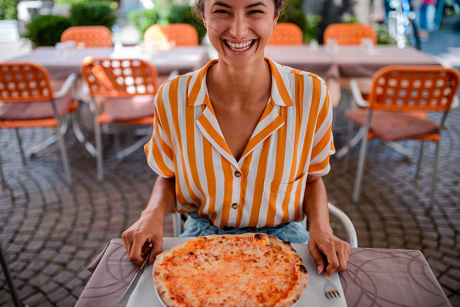 Happy woman eating pizza. Photograph by MStudioImages
