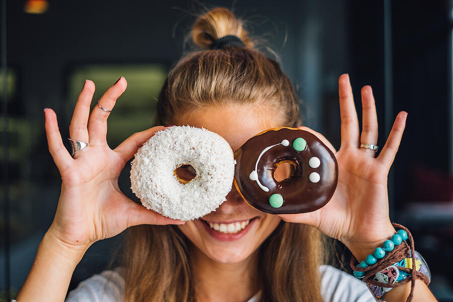 Happy woman holding donuts Photograph by Macarosha