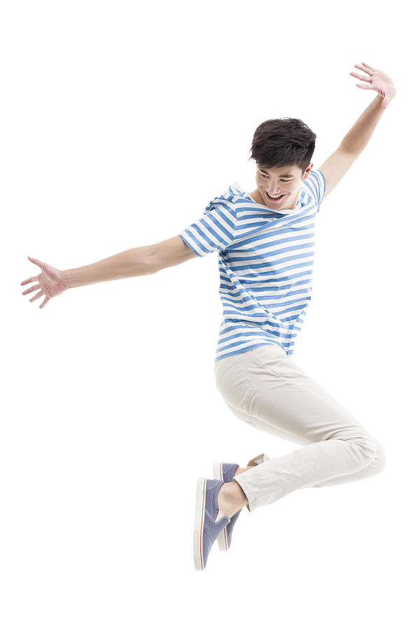 Happy young man jumping Photograph by BJI / Blue Jean Images