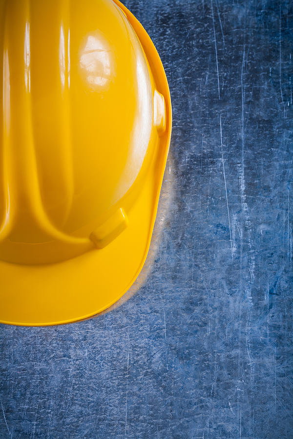 Hard hat on scratched vintage metallic background construction c Photograph by Mihalec
