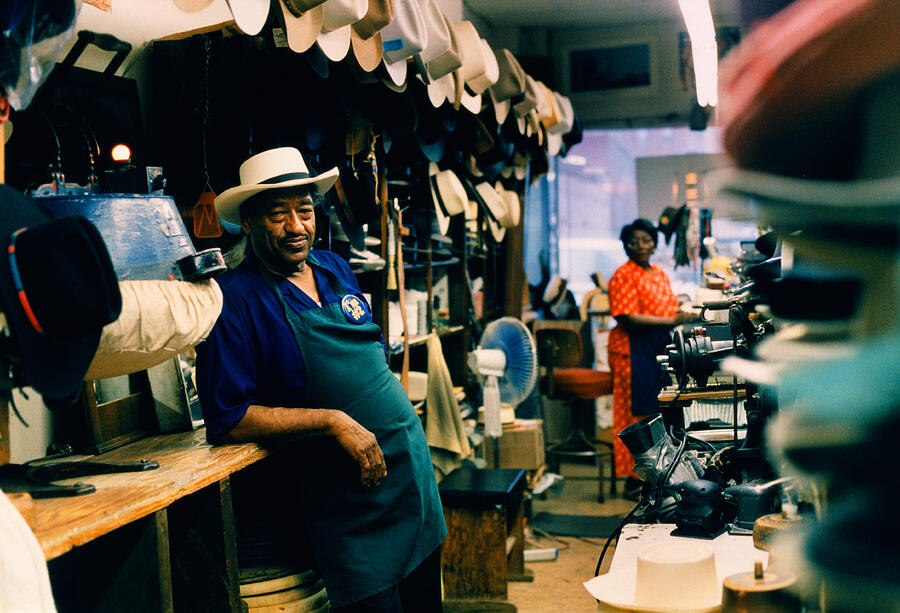 Hat maker in his shop, wife in background, Tennessee, USA Photograph by Andy Sacks