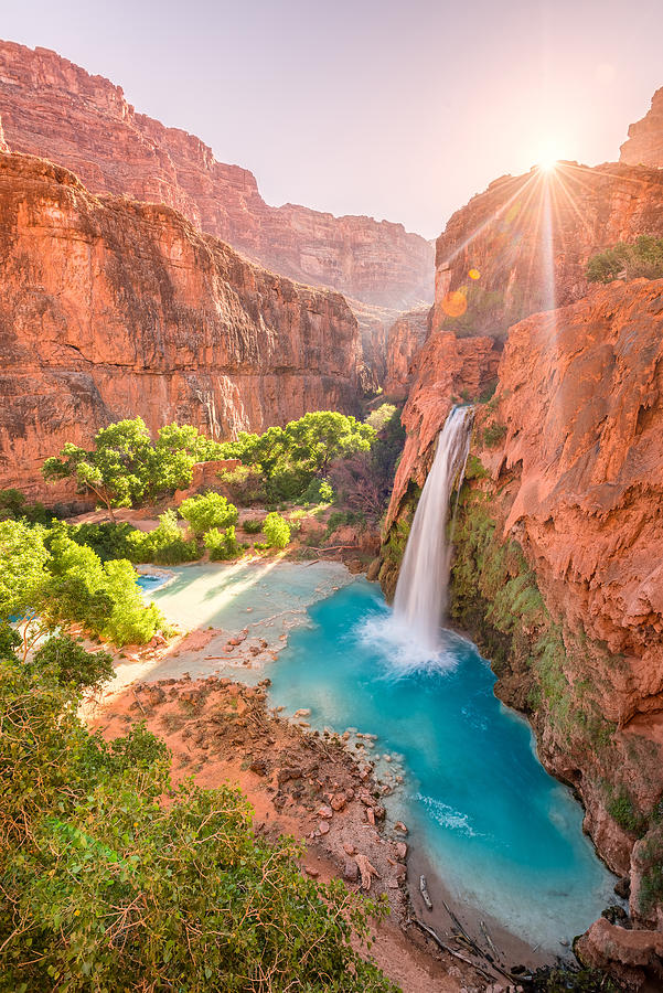 Havasu Falls in Arizona plunges in turquoise waters as the sun rises above the cliffside Photograph by Kevin Boutwell