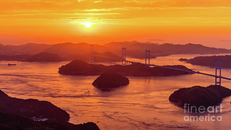 Hazy sunset on Kurushima Kaikyo Bridge and Kurushima Strait Photograph by Lyl Dil Creations