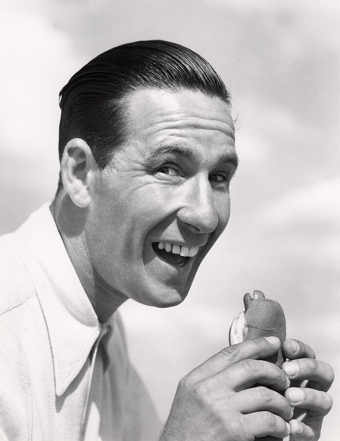 Head Shot Of Smiling Man With Wide Open Mouth And Head Pushed Forward About To Eat A Hotdog In A Frankfurter Roll Wearing A White Shirt Buck Teeth Hair. Photograph by H. Armstrong Roberts