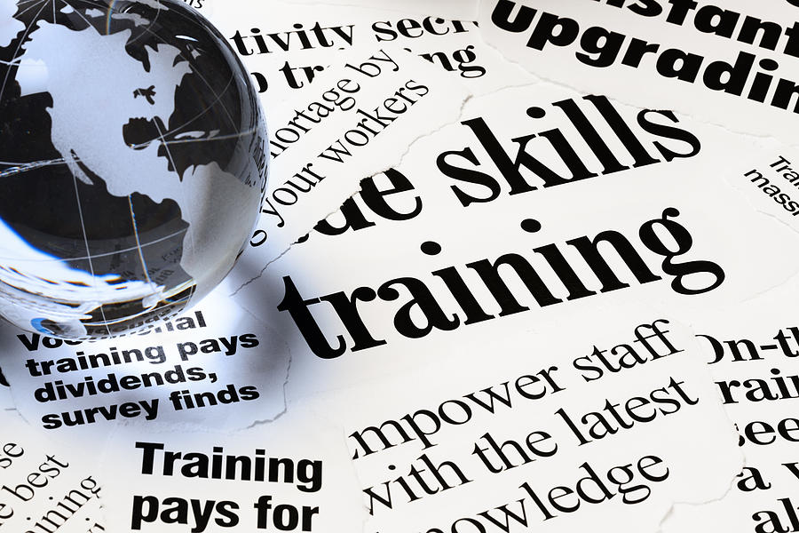 Headlines on staff empowerment through training under globe paperweight Photograph by RapidEye