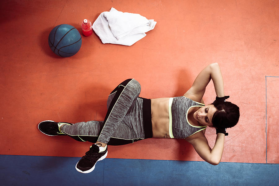 Healthy female athlete doing crunches in gym from above Photograph by Drazen Lovric