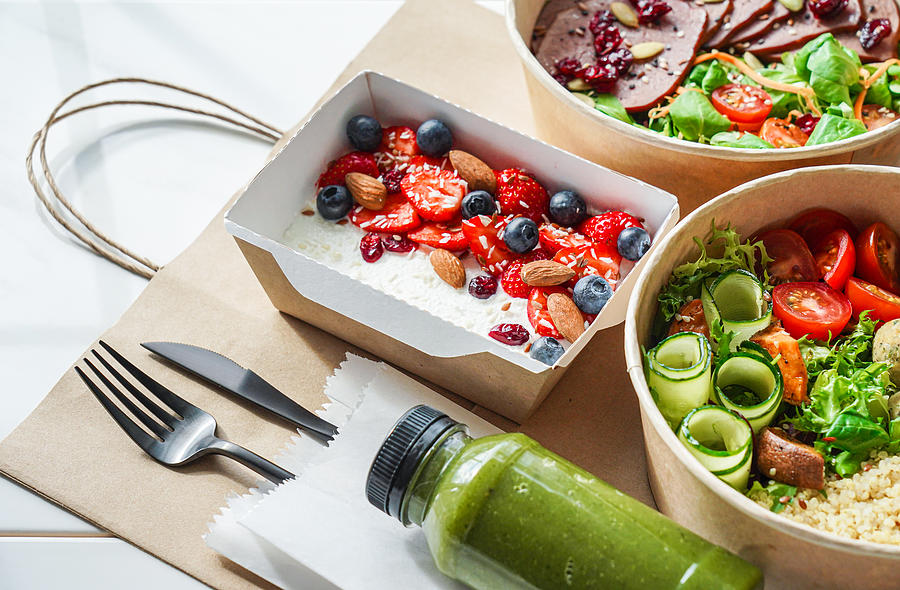 Healthy meal slimming diet plan daily ready menu background, organic fresh dishes and smoothie, fork knife on paper eco bag as food delivery courier service at home in office concept, close up view. Photograph by Insta_photos