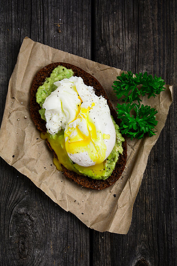 Healthy toast with avocado and poached egg Photograph by Arx0nt