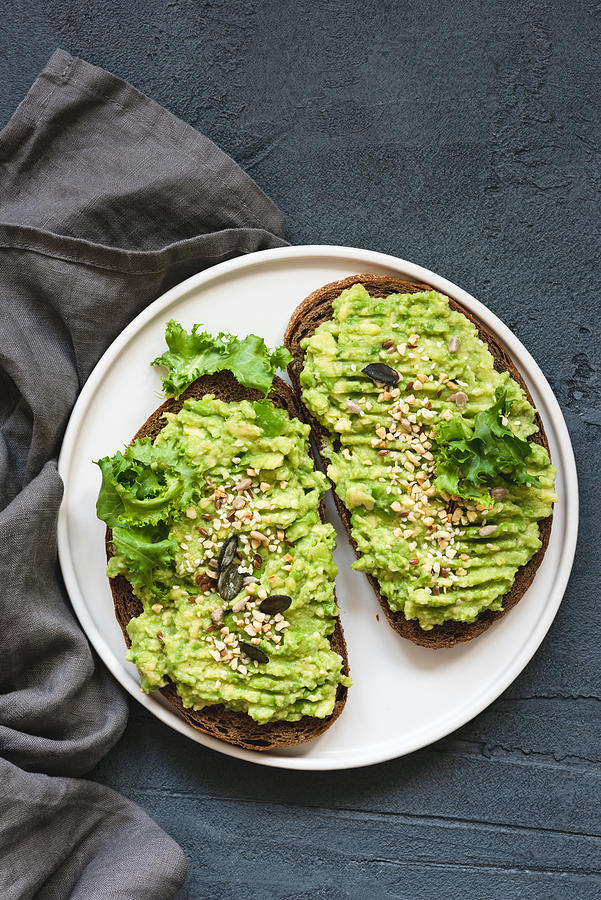 Healthy toast with mashed avocado and seeds Photograph by Arx0nt
