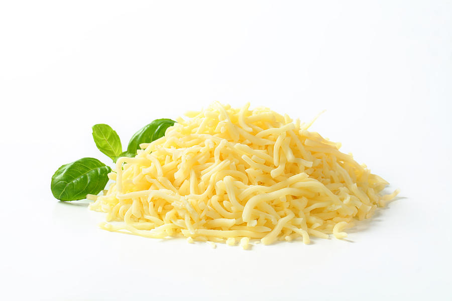 Heap of grated cheese on white background Photograph by Milanfoto