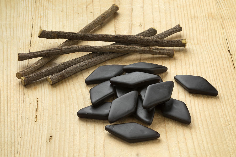 Heap of  Licorice roots and black salt licorice confectionary Photograph by PicturePartners