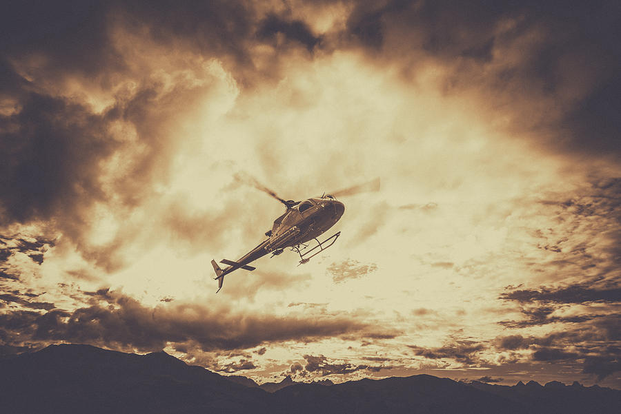 Helicopter Flying in Mountains With Dark Clouds Photograph by Christopher Ames