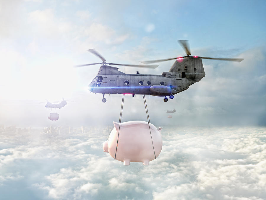 Helicopters carrying piggy banks over clouds Photograph by Colin Anderson Productions pty ltd