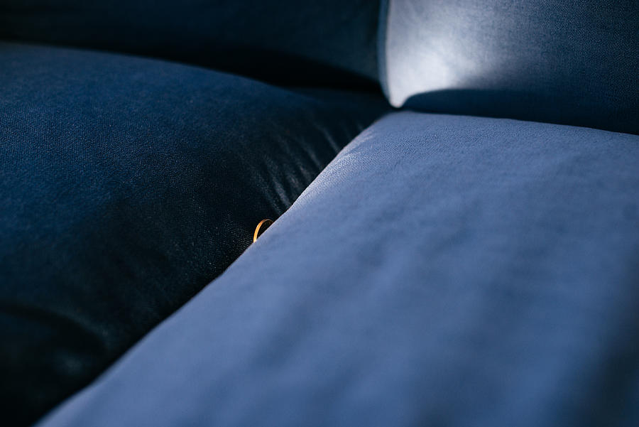 Hidden coin between sofa pillows. Photograph by Guido Mieth