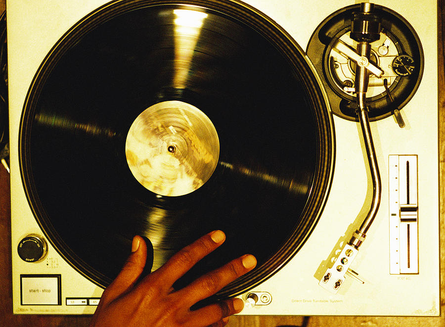 High Angle Close-up Of A Hand Scratching A Vinyl Record On A Turntable Photograph by Stockbyte