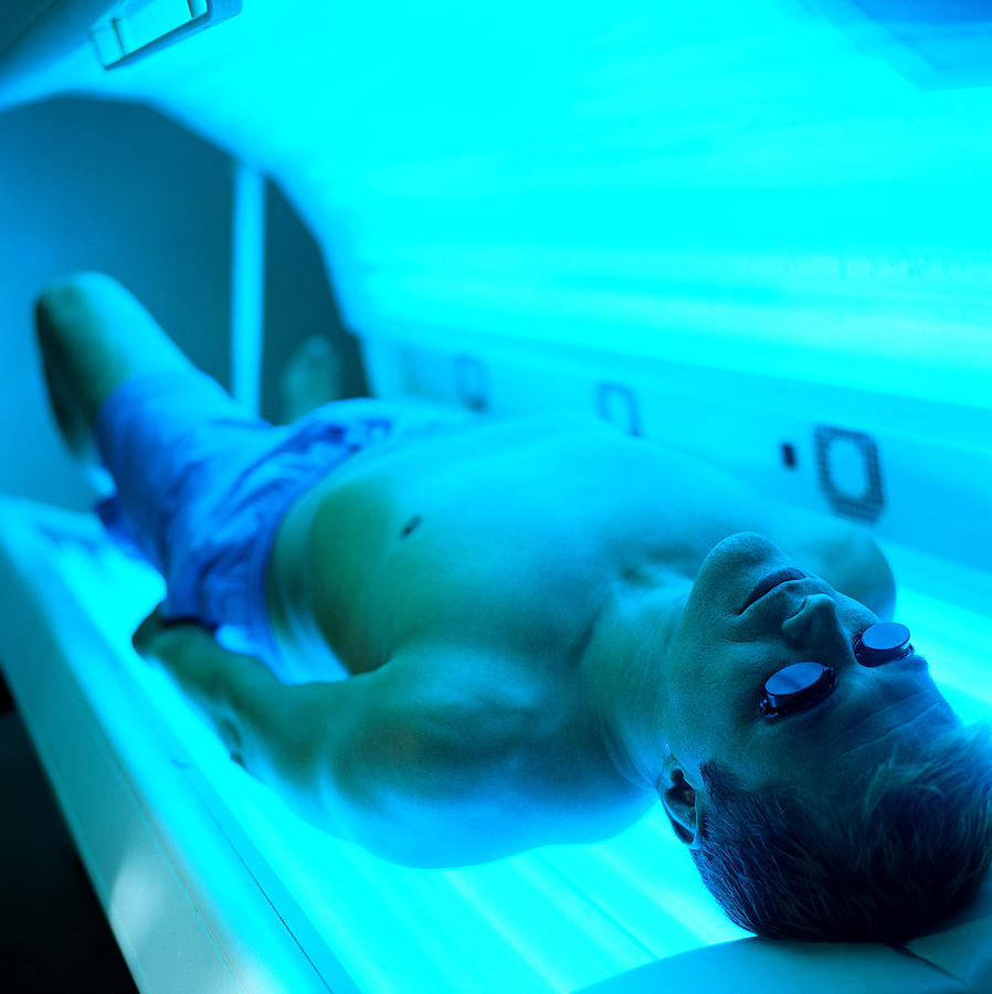 High Angle View Of A Man Lying In A Tanning Machine Photograph by Stockbyte
