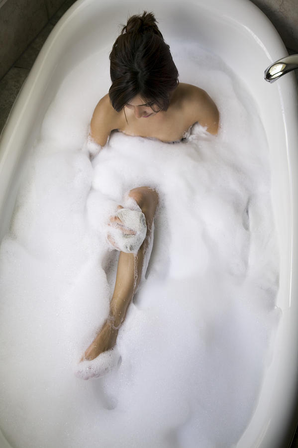 High angle view of a young woman sitting in a bathtub Photograph by Digital Vision