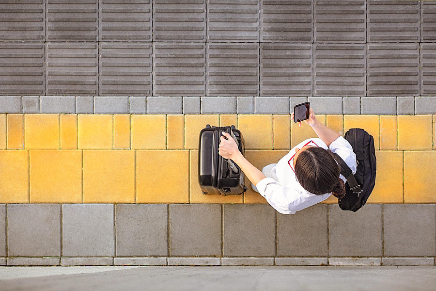 High angle view of a young woman using her smart phone Photograph by Gruizza
