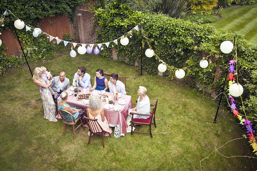 High angle view of family and friends around table at garden party Photograph by Cultura RM Exclusive/Grant Squibb