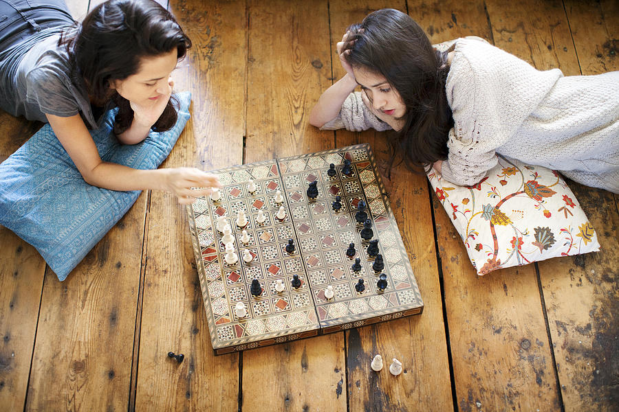 High angle view of sisters playing chess at home Photograph by Cavan Images
