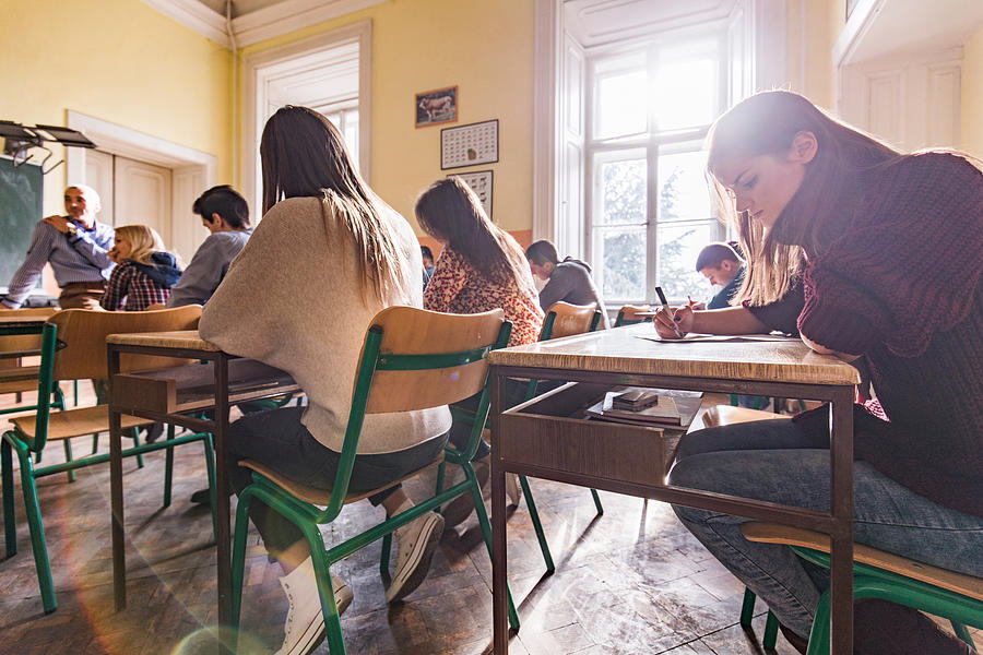 High school students writing a test in the classroom. Photograph by Skynesher