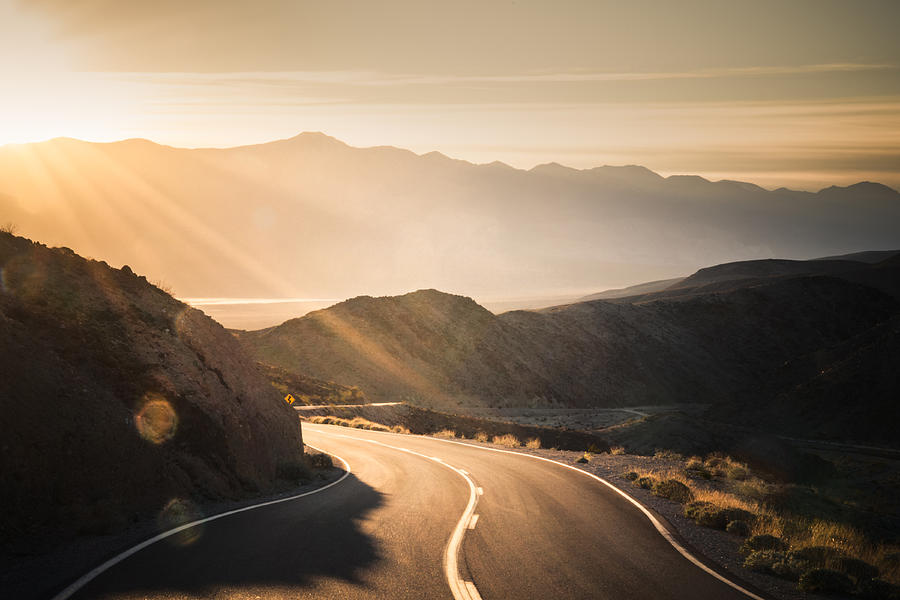 Highway at sunrise, going into Death Valley National Park Photograph by Wildroze
