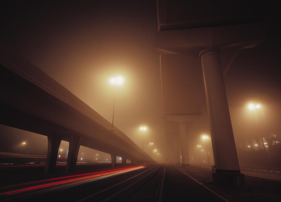 Highway exit shrouded in mist in Dubai at dawn. Photograph by EschCollection