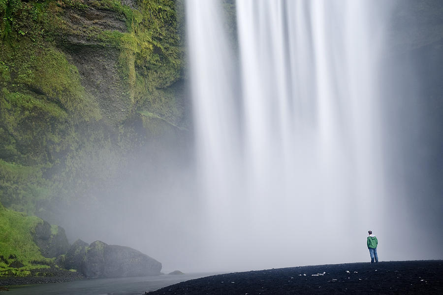 Hiker admiring giant waterfall Photograph by Cultura RM Exclusive/Ben Pipe Photography