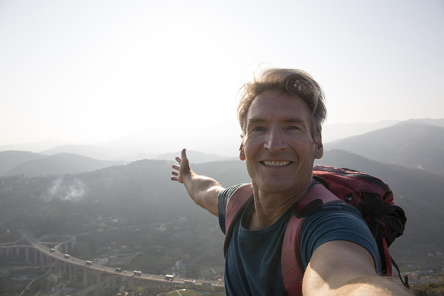 Hiker takes selfie portrait on mountain top Photograph by Ascent/PKS Media Inc.