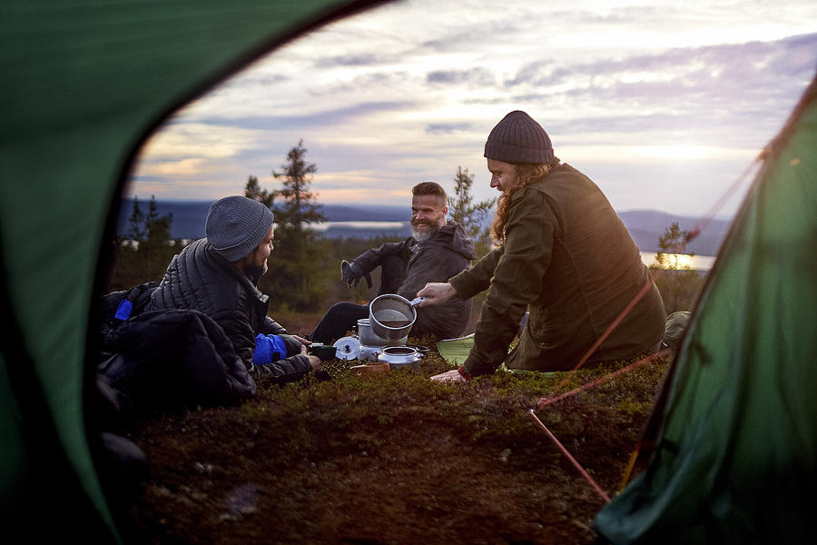 Hikers preparing meal, chatting in front of tent, Keimiotunturi, Lapland, Finland Photograph by Aleksi Koskinen