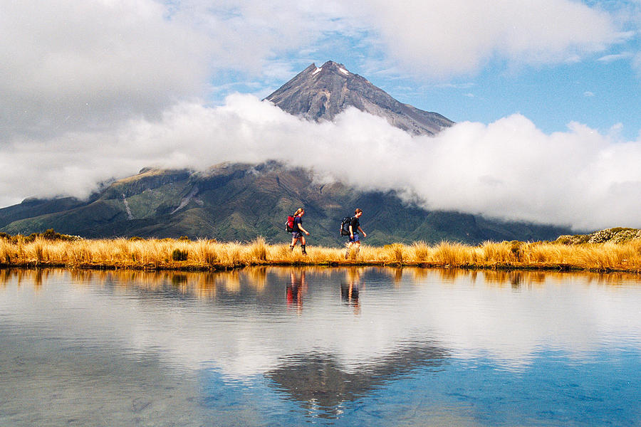 Hikers Reflection of Mount Taranaki Egmont in natural lake middle Photograph by Wilpunt