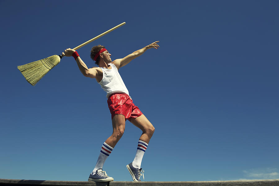 Hipster Nerd Young Man Throwing Broom Javelin Outdoors Blue Sky Photograph by PeskyMonkey