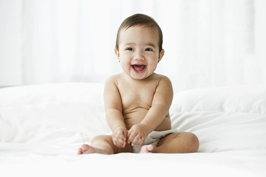 Hispanic baby smiling on bed Photograph by Jose Luis Pelaez Inc