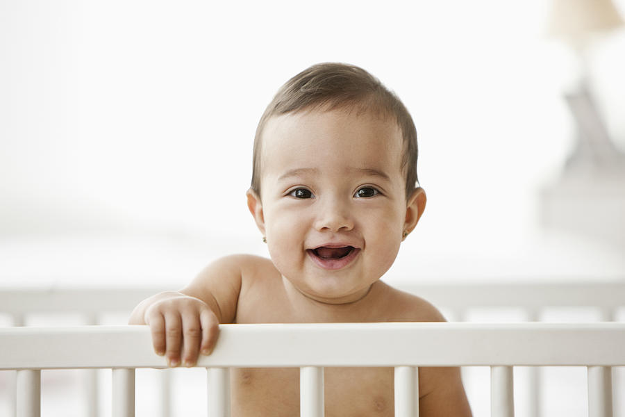 Hispanic baby standing in crib Photograph by Jose Luis Pelaez Inc
