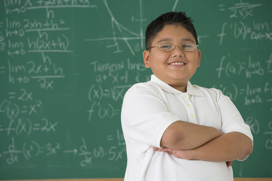 Hispanic boy in front of blackboard Photograph by Jose Luis Pelaez Inc