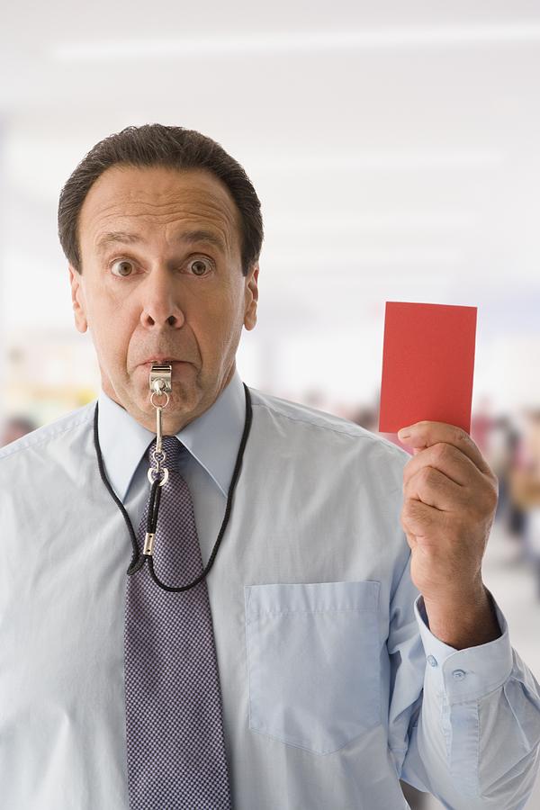 Hispanic businessman holding red card and blowing whistle Photograph by Jose Luis Pelaez Inc