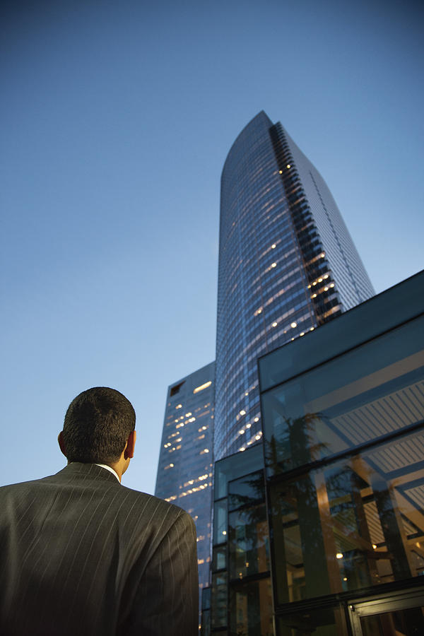 Hispanic businessman looking at city highrise Photograph by Jetta Productions Inc