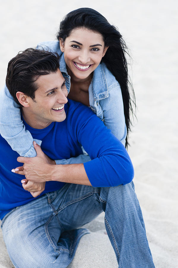 Hispanic couple hugging on beach Photograph by Kevin Dodge