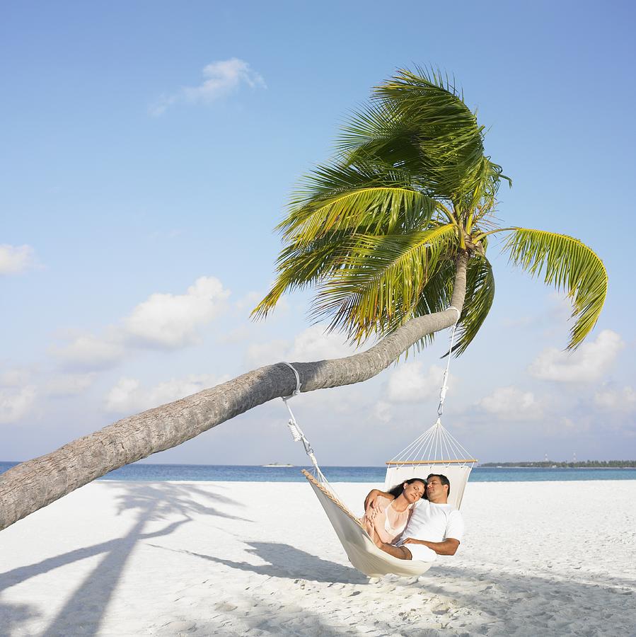 Hispanic couple in hammock at beach Photograph by Blend Images - Dave & Les Jacobs