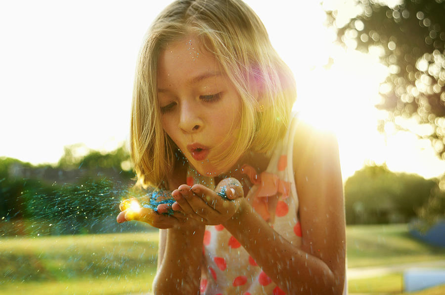 Hispanic girl playing with glitter outdoors Photograph by Karin Dreyer