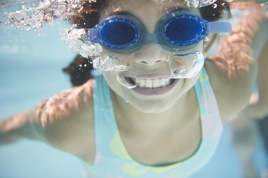 Hispanic girl swimming under water Photograph by JGI/Jamie Grill