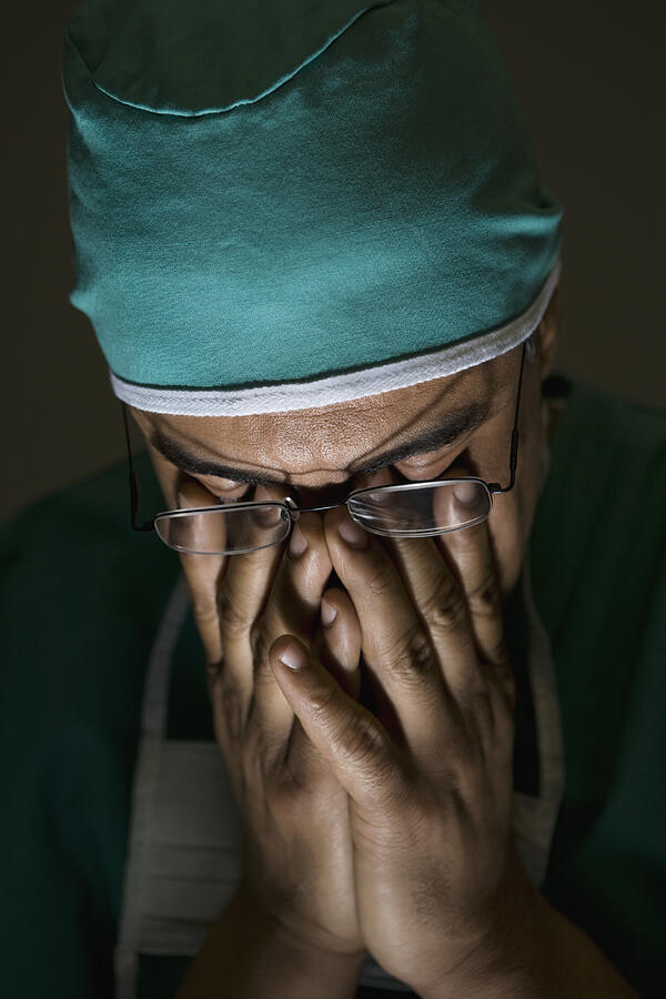 Hispanic male doctor with head in hands Photograph by Jose Luis Pelaez Inc
