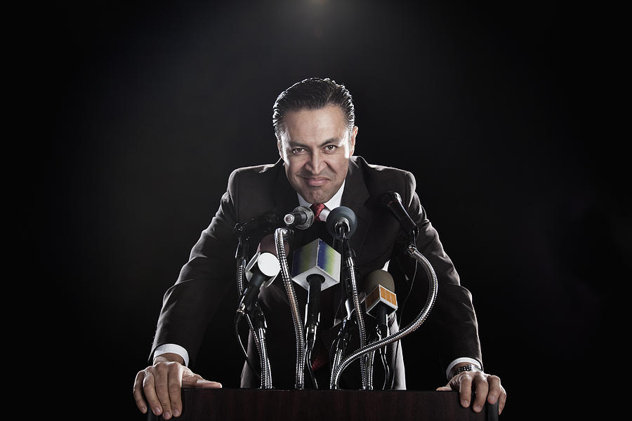 Hispanic man standing at podium with microphones Photograph by Hill Street Studios
