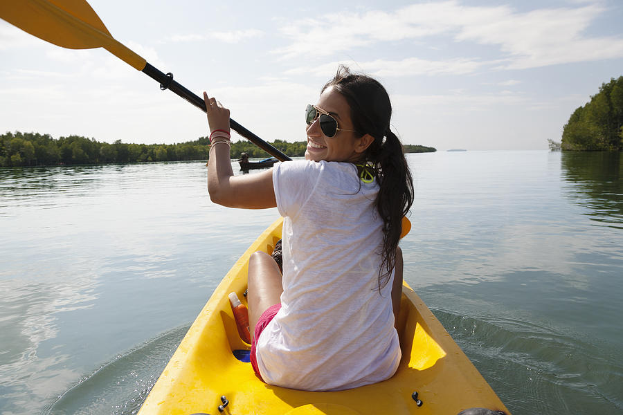 Hispanic woman paddling kayak Photograph by Blend Images - Roberto Westbrook